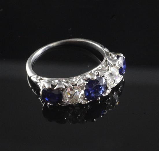 A 1920s/1930s white gold, sapphire and diamond graduated five stone half hoop ring, size R.